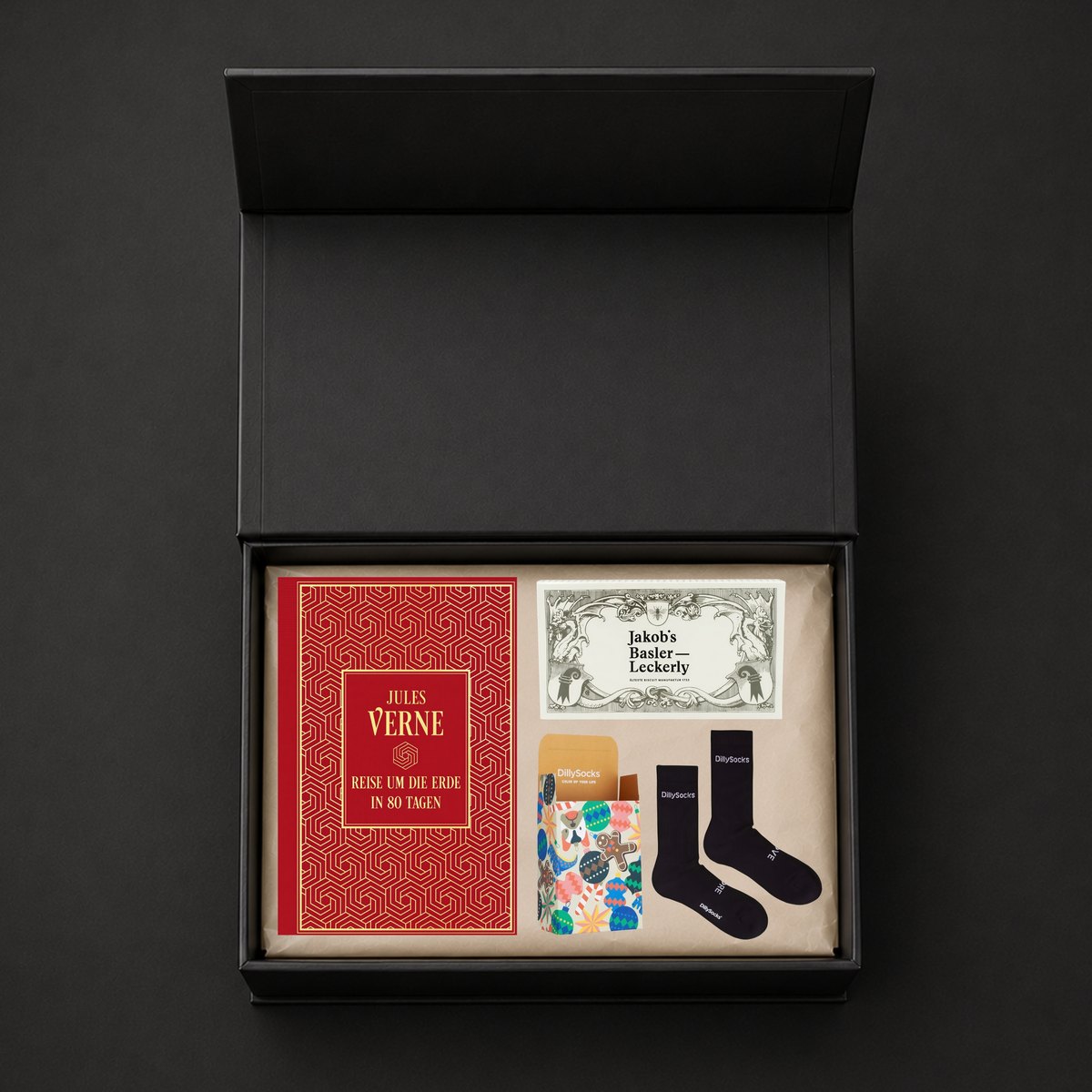 Offene schwarze Box mit Buch, Leckerly und Socken